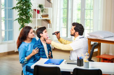 Hintli Asyalı erkek doktor, modern klinikte genç erkek çocuklarına steteskop kullanarak genel semptomları kontrol ediyor.