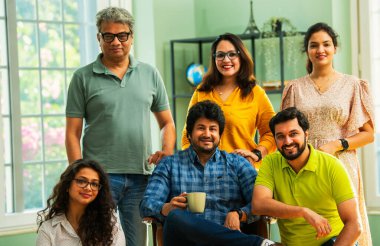 Genç girişimcilerden oluşan Hint Asya dinamik ekibi modern yaratıcı ofiste başarıyı kutluyor. Kameraya, takım çalışmasına, lidere gülümseyen iş adamlarına güveniyorlar.