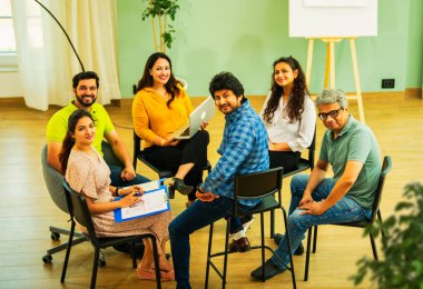 Hint Asyalı bir grup iş toplantısında, çeşitli ofis ortamlarında ruh sağlığı ve desteği tartışıyorlar. Profesyonel bir konferans salonunda takım iletişimi, işbirliği ve sağlık.