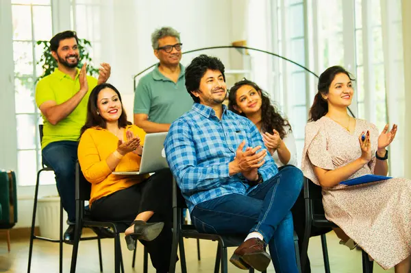 Hintli Asyalı genç iş adamları ya da girişim ekibi modern bir konferans salonunda kurumsal bir konuşma, liderlik dersi, eğitim oturumu için toplanıyor.