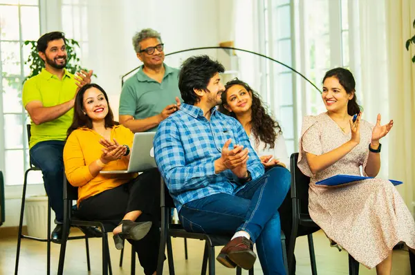 Hintli Asyalı genç iş adamları ya da girişim ekibi modern bir konferans salonunda kurumsal bir konuşma, liderlik dersi, eğitim oturumu için toplanıyor.