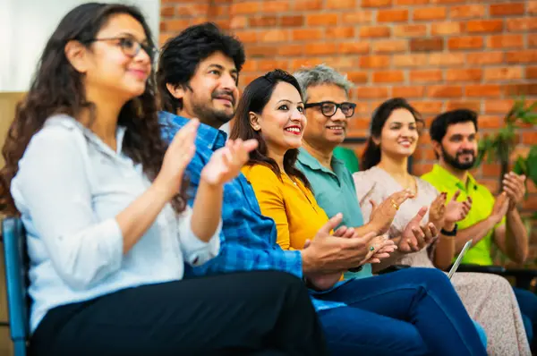 Hintli Asyalı genç iş adamları ya da girişim ekibi modern bir konferans salonunda kurumsal bir konuşma, liderlik dersi, eğitim oturumu için toplanıyor.