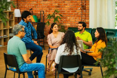 Hint Asyalı bir grup iş toplantısında, çeşitli ofis ortamlarında ruh sağlığı ve desteği tartışıyorlar. Profesyonel bir konferans salonunda takım iletişimi, işbirliği ve sağlık.