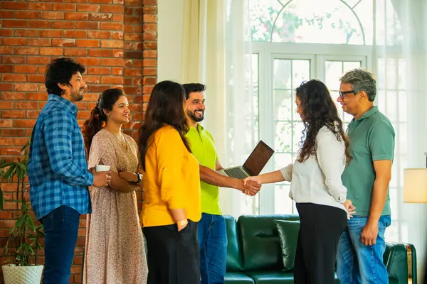 Hint Asya iş kurma ekibi modern bir ofiste el sıkışıyor, işbirliğini, takım çalışmasını, başarıyı, ağı ve dinamik bir çalışma alanında kurumsal iletişimi sembolize ediyor.