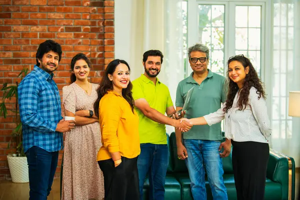 Hint Asya iş kurma ekibi modern bir ofiste el sıkışıyor, işbirliğini, takım çalışmasını, başarıyı, ağı ve dinamik bir çalışma alanında kurumsal iletişimi sembolize ediyor.
