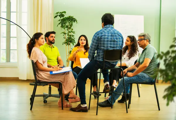 Hint Asyalı bir grup iş toplantısında, çeşitli ofis ortamlarında ruh sağlığı ve desteği tartışıyorlar. Profesyonel bir konferans salonunda takım iletişimi, işbirliği ve sağlık.