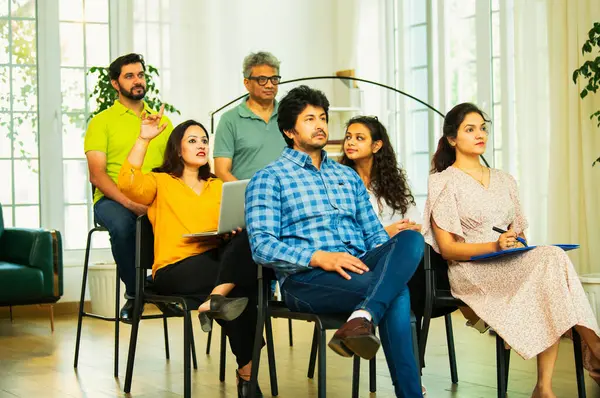 Hintli Asyalı genç iş adamları ya da girişim ekibi modern bir konferans salonunda kurumsal bir konuşma, liderlik dersi, eğitim oturumu için toplanıyor.