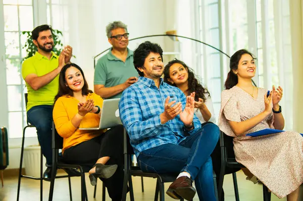 Hintli Asyalı genç iş adamları ya da girişim ekibi modern bir konferans salonunda kurumsal bir konuşma, liderlik dersi, eğitim oturumu için toplanıyor.