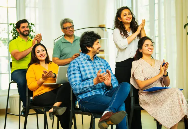 Hintli Asyalı genç iş adamları ya da girişim ekibi modern bir konferans salonunda kurumsal bir konuşma, liderlik dersi, eğitim oturumu için toplanıyor.