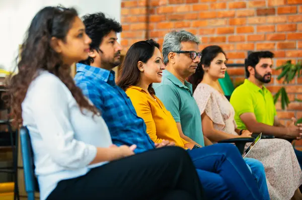 Hintli Asyalı genç iş adamları ya da girişim ekibi modern bir konferans salonunda kurumsal bir konuşma, liderlik dersi, eğitim oturumu için toplanıyor.
