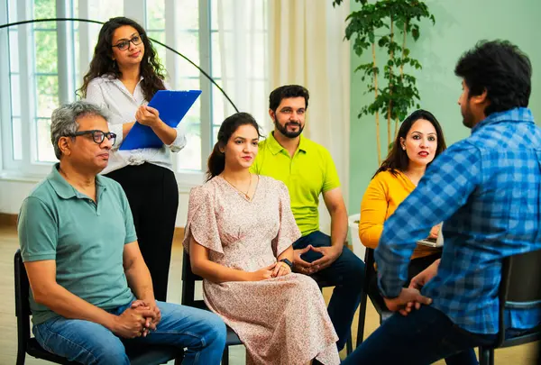 Hintli Asyalı genç iş adamları ya da girişim ekibi samimi modern ofiste takım liderlerinden stratejik bir brifing alarak, ortak çalışma alanındaki fikirleri tartıştılar.