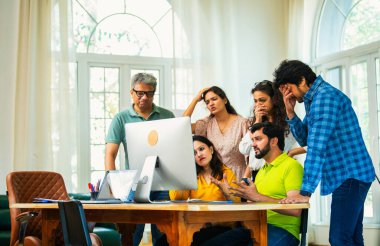 Hindistanlı Asyalı genç iş adamları yeni ortakları rahat ofislerinde bilgisayar üzerinde çok önemli bir proje üzerinde çalışıyorlar. Beklenmedik bir başarısızlık ya da gerilemeyle karşılaştıklarında birden hayal kırıklığına uğradılar, üzüldüler, üzüldüler.