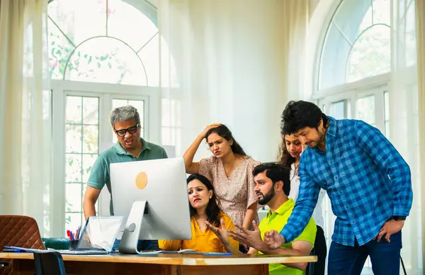 Hindistanlı Asyalı genç iş adamları yeni ortakları rahat ofislerinde bilgisayar üzerinde çok önemli bir proje üzerinde çalışıyorlar. Beklenmedik bir başarısızlık ya da gerilemeyle karşılaştıklarında birden hayal kırıklığına uğradılar, üzüldüler, üzüldüler.