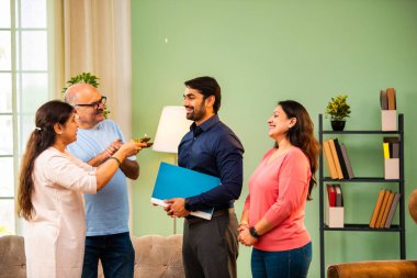 Genç Hintli bir adam iş görüşmesini kırar, üst düzey ebeveynler ve kız kardeşlerle tanışmak için yönetici kıyafetiyle eve döner, aileye sarılır, kutsanmak ister, başarıyı kutlar ve neşeli duygusal anı paylaşır.