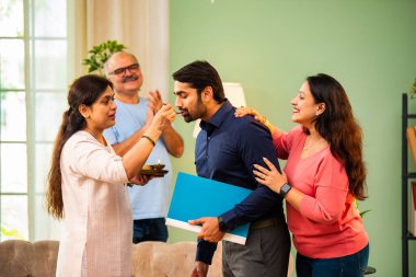 Genç Hintli bir adam iş görüşmesini kırar, üst düzey ebeveynler ve kız kardeşlerle tanışmak için yönetici kıyafetiyle eve döner, aileye sarılır, kutsanmak ister, başarıyı kutlar ve neşeli duygusal anı paylaşır.