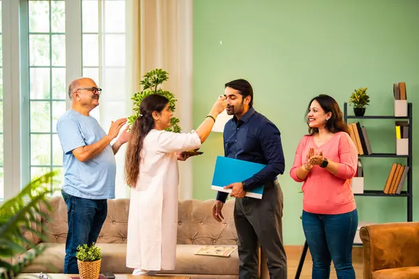 Genç Hintli bir adam iş görüşmesini kırar, üst düzey ebeveynler ve kız kardeşlerle tanışmak için yönetici kıyafetiyle eve döner, aileye sarılır, kutsanmak ister, başarıyı kutlar ve neşeli duygusal anı paylaşır.