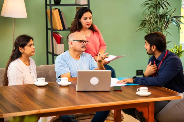 Dizüstü bilgisayardaki başarılı istişareden sonra kızı olan Hintli yaşlı çift erkek mali danışmanla tokalaşıyor. ev kredisi, sigorta, tasarruf veya gülümsemeyle yatırım anlaşması