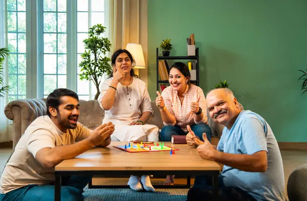 Kapalı alanlarda ludo masası oyunu oynuyorlar, dört kişilik Hint ailesi, yaşlı ebeveynler, genç yetişkin bir çocuk ve kız evdeki modern sıcak oturma odasında birlikte otururken kaliteli vakit geçirmenin keyfini çıkarıyorlar.