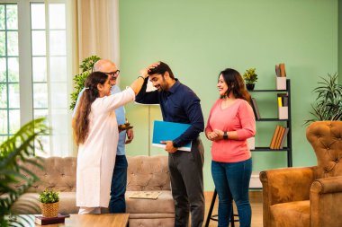 Genç Hintli bir adam iş görüşmesini kırar, üst düzey ebeveynler ve kız kardeşlerle tanışmak için yönetici kıyafetiyle eve döner, aileye sarılır, kutsanmak ister, başarıyı kutlar ve neşeli duygusal anı paylaşır.