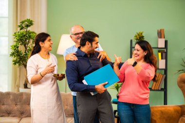 Genç Hintli bir adam iş görüşmesini kırar, üst düzey ebeveynler ve kız kardeşlerle tanışmak için yönetici kıyafetiyle eve döner, aileye sarılır, kutsanmak ister, başarıyı kutlar ve neşeli duygusal anı paylaşır.