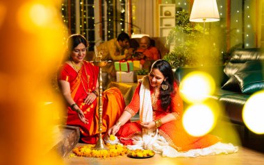 Samai 'nin etrafındaki çiçek Rangoli' sini süsleyen Hintli genç kız geleneksel Hindu kıdemli anne Hint festivali için neşe içinde hazırlanıyor Diwali akşam saatlerinde kapalı bir yerde moda ve renkli tasarım ile kutlama yapıyor.