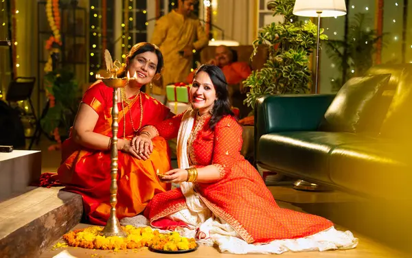 Samai 'nin etrafındaki çiçek Rangoli' sini süsleyen Hintli genç kız geleneksel Hindu kıdemli anne Hint festivali için neşe içinde hazırlanıyor Diwali akşam saatlerinde kapalı bir yerde moda ve renkli tasarım ile kutlama yapıyor.