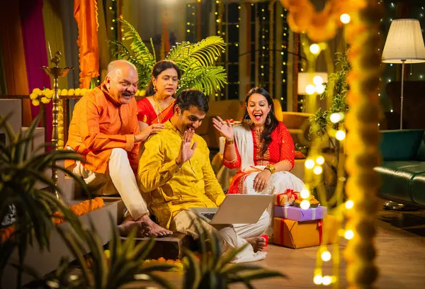 Hindu Diwali festivalini kutlayan dört çocuklu Hintli aile, dizüstü bilgisayarlı video görüşmelerine katılıyor. Ev içi yemek masasında şeker ve ışıklarla kutluyorlar.