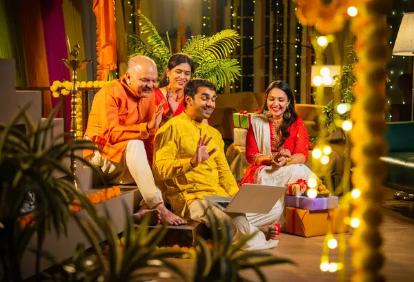 Hindu Diwali festivalini kutlayan dört çocuklu Hintli aile, dizüstü bilgisayarlı video görüşmelerine katılıyor. Ev içi yemek masasında şeker ve ışıklarla kutluyorlar.