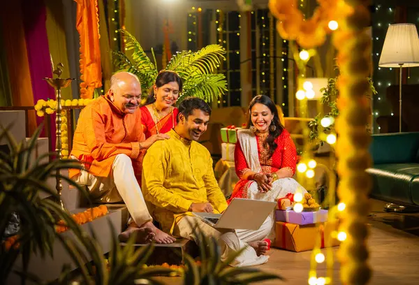 Hindu Diwali festivalini kutlayan dört çocuklu Hintli aile, dizüstü bilgisayarlı video görüşmelerine katılıyor. Ev içi yemek masasında şeker ve ışıklarla kutluyorlar.