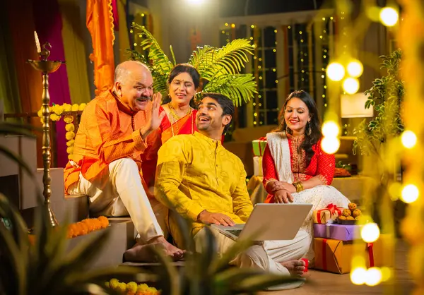 Hindu Diwali festivalini kutlayan dört çocuklu Hintli aile, dizüstü bilgisayarlı video görüşmelerine katılıyor. Ev içi yemek masasında şeker ve ışıklarla kutluyorlar.