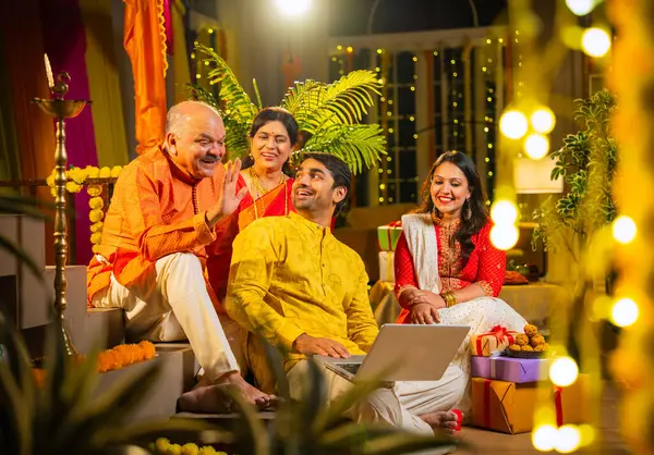 Hindu Diwali festivalini kutlayan dört çocuklu Hintli aile, dizüstü bilgisayarlı video görüşmelerine katılıyor. Ev içi yemek masasında şeker ve ışıklarla kutluyorlar.