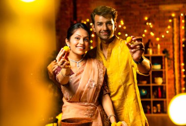 Hint çifti Diwali 'de süslü mutfakta laddu yapıyor. Işıklar ve çiçek çelenkleriyle dolu, neşe içinde geleneksel laddoo' yu hazırlıyor, sergiliyor ya da birlikte yiyor.