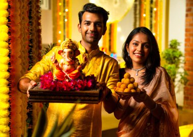 Ganesh Idol ve Joy 'u karşılayan Hintli çift, Ganpati Bappa Idol' u tutan, Ganesh Festivali 'nde gülümseyen Bappa Morya, Ganesh Festivali' nde gülümseyen Ganpati Bappa Idol 'un genç eşi.