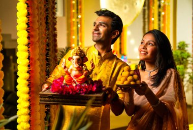 Ganesh Idol ve Joy 'u karşılayan Hintli çift, Ganpati Bappa Idol' u tutan, Ganesh Festivali 'nde gülümseyen Bappa Morya, Ganesh Festivali' nde gülümseyen Ganpati Bappa Idol 'un genç eşi.