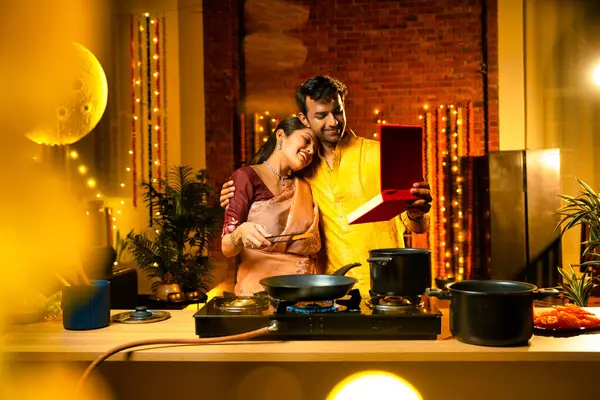 Hintli koca karısına bir kolye hediye eder ve Diwali festivalinde onu şaşırtır. O da mutfakta yemek pişirirken neşeli, neşeli anları yakalar.