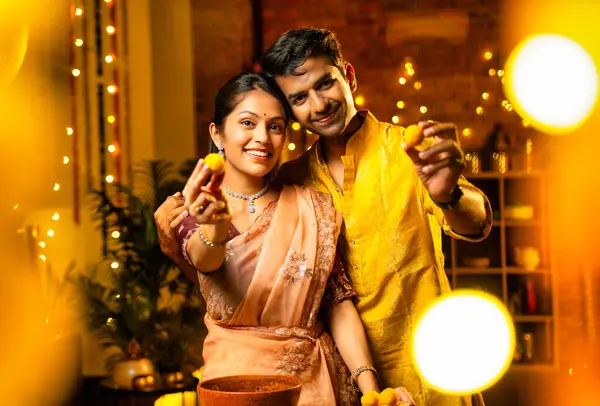 Hint çifti Diwali 'de süslü mutfakta laddu yapıyor. Işıklar ve çiçek çelenkleriyle dolu, neşe içinde geleneksel laddoo' yu hazırlıyor, sergiliyor ya da birlikte yiyor.