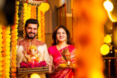 Ganesh Idol ve Joy 'u karşılayan Hintli çift Ganesh Idol, Ganpati Bappa Idol, Puja Thali, Ganesh Festivali Kutlamaları sırasında gülümseyen ve Bappa Morya' yı tezahürat yapan