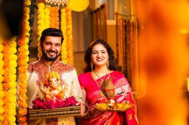 Ganesh Idol ve Joy 'u karşılayan Hintli çift Ganesh Idol, Ganpati Bappa Idol, Puja Thali, Ganesh Festivali Kutlamaları sırasında gülümseyen ve Bappa Morya' yı tezahürat yapan