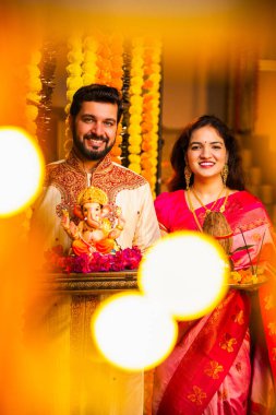 Ganesh Idol ve Joy 'u karşılayan Hintli çift Ganesh Idol, Ganpati Bappa Idol, Puja Thali, Ganesh Festivali Kutlamaları sırasında gülümseyen ve Bappa Morya' yı tezahürat yapan