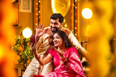 Diwali Video Call 'dan dilek diliyor. Geleneksel Etnik Giyimli Hintli genç çift Diwali Festivali 'nde Işık ve Şölen Dekorasyonu' nda Akrabaları bağlamak için akıllı telefonu kullanıyor