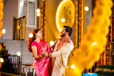 Marigold Çelenkleri ve Bayram Işığı ile süslenmiş, Hint Festivali 'nin diwali bayramını etnik kıyafetlerle kutlayan çift.