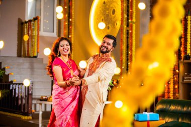 Marigold Çelenkleri ve Bayram Işığı ile süslenmiş, Hint Festivali 'nin diwali bayramını etnik kıyafetlerle kutlayan çift.