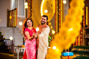 Marigold Çelenkleri ve Bayram Işığı ile süslenmiş, Hint Festivali 'nin diwali bayramını etnik kıyafetlerle kutlayan çift.