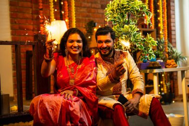 Geleneksel Şenlik Giysilerinde Dekoratif Merdivenlerde Birlikte Yanan Hintli Çift, Diwali Gecesinde Parıltı ve Havai fişeklerle Neşeli Gülümseyen ve Kutlayan