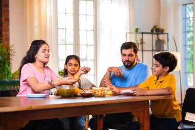 Aile evde panipuri atıştırmalıkları yiyor, Hintli baba, anne, oğul kız rahat oturma odasındaki yemek masasında golgappanın tadını çıkarırken sohbet ediyor, gülüyor ve kaliteli zaman geçiriyor.