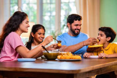 Aile evde panipuri atıştırmalıkları yiyor, Hintli baba, anne, oğul kız rahat oturma odasındaki yemek masasında golgappanın tadını çıkarırken sohbet ediyor, gülüyor ve kaliteli zaman geçiriyor.