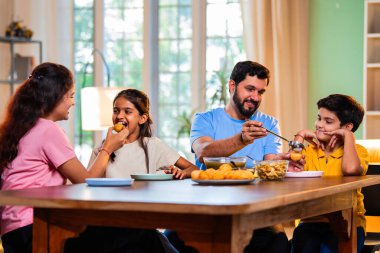 Aile evde panipuri atıştırmalıkları yiyor, Hintli baba, anne, oğul kız rahat oturma odasındaki yemek masasında golgappanın tadını çıkarırken sohbet ediyor, gülüyor ve kaliteli zaman geçiriyor.