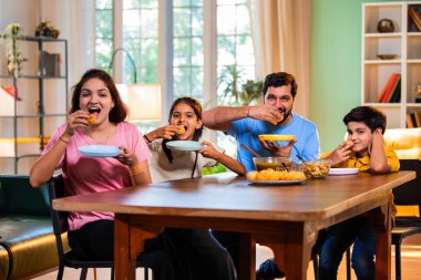 Aile evde panipuri atıştırmalıkları yiyor, Hintli baba, anne, oğul kız rahat oturma odasındaki yemek masasında golgappanın tadını çıkarırken sohbet ediyor, gülüyor ve kaliteli zaman geçiriyor.