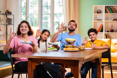 Aile evde panipuri atıştırmalıkları yiyor, Hintli baba, anne, oğul kız rahat oturma odasındaki yemek masasında golgappanın tadını çıkarırken sohbet ediyor, gülüyor ve kaliteli zaman geçiriyor.
