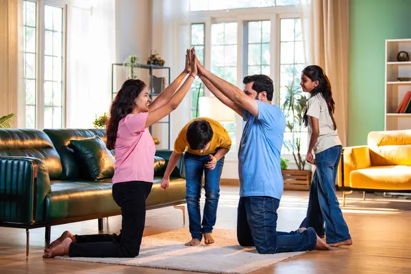 Aile Londra Köprüsü oyunu oynuyor. Modern evlerin içine düşüyorlar. Hintli anne, baba, oğul, kız.